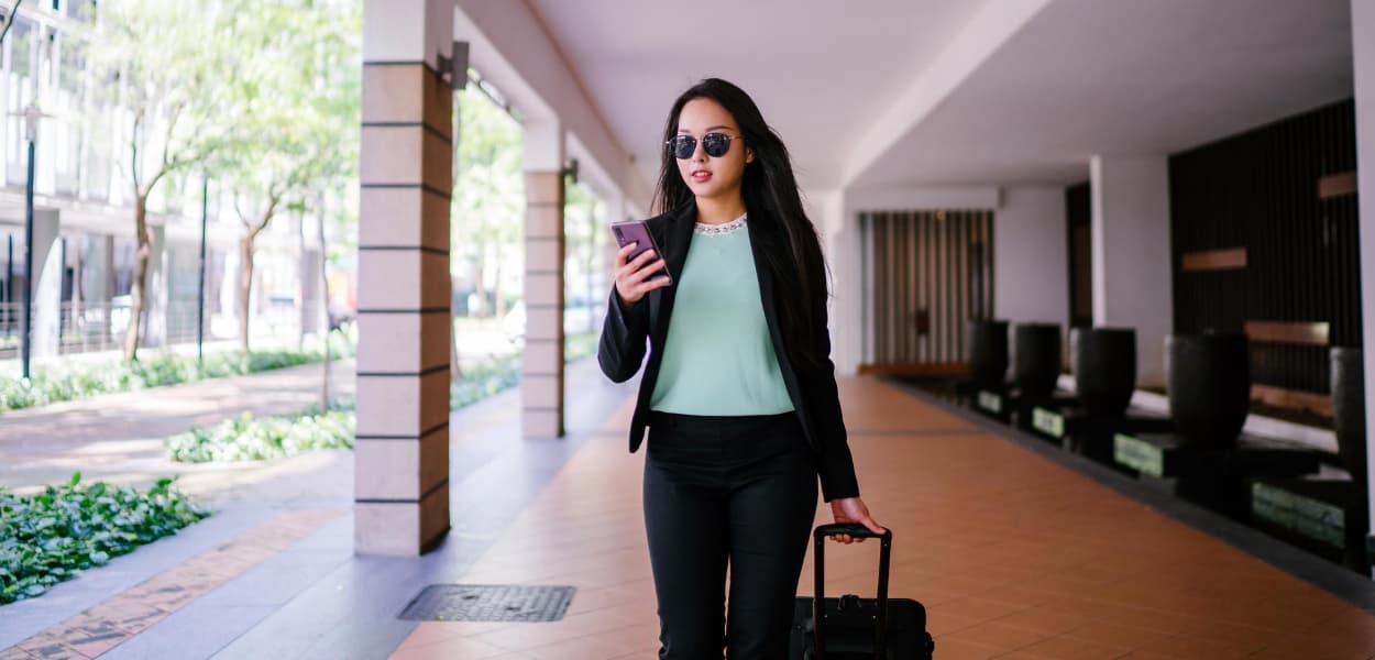 Business traveler with luggage walking to Contact Limo corporate car service pickup