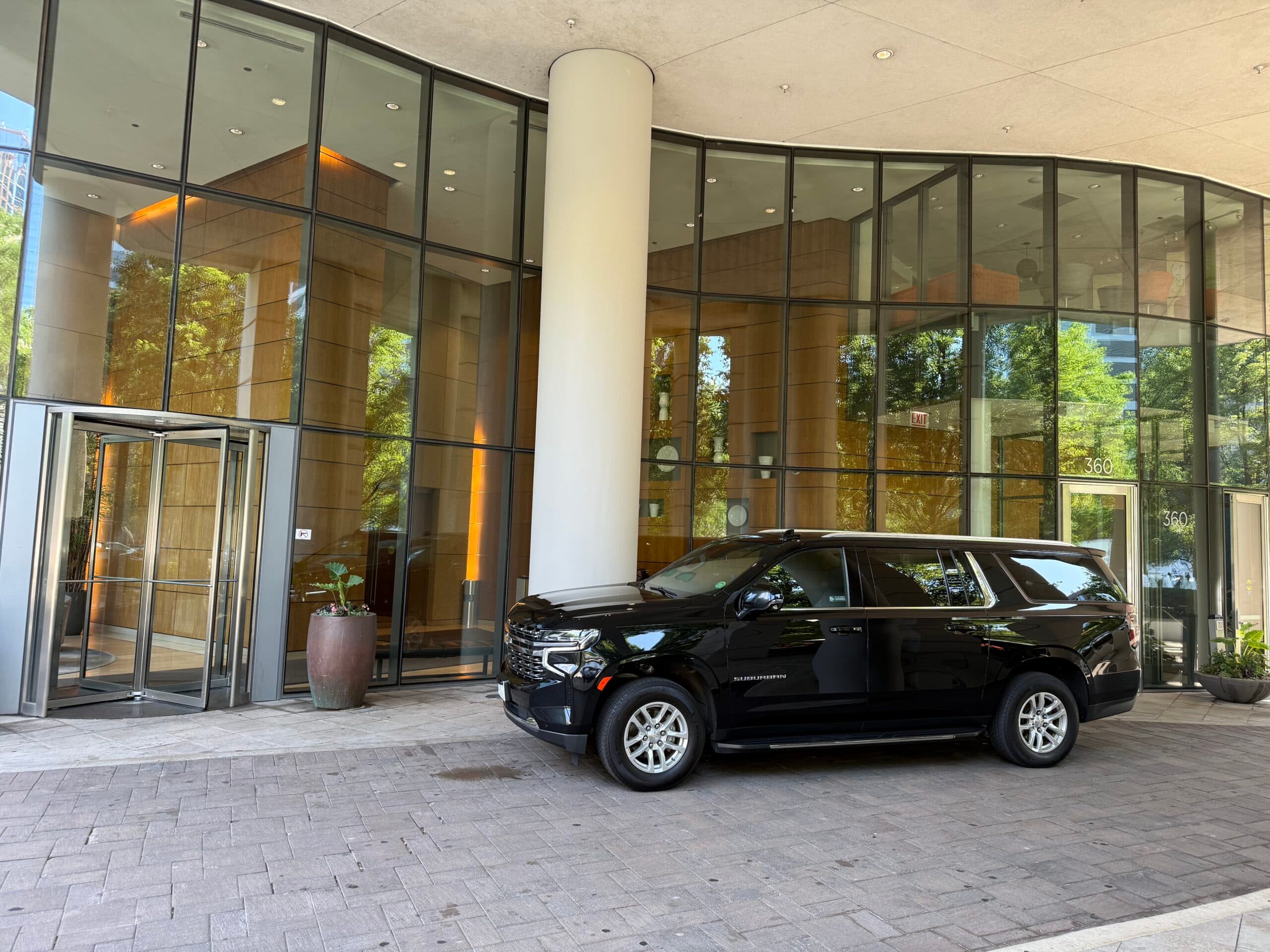 Contact Limo LLC black luxury SUV at downtown Chicago hotel entrance — corporate limo service