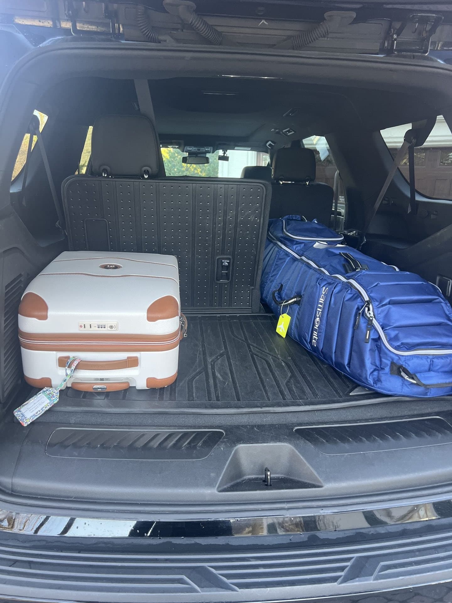 Luggage loaded in Contact Limo Suburban cargo area for airport transfer, Samsonite bag and hard-shell suitcase