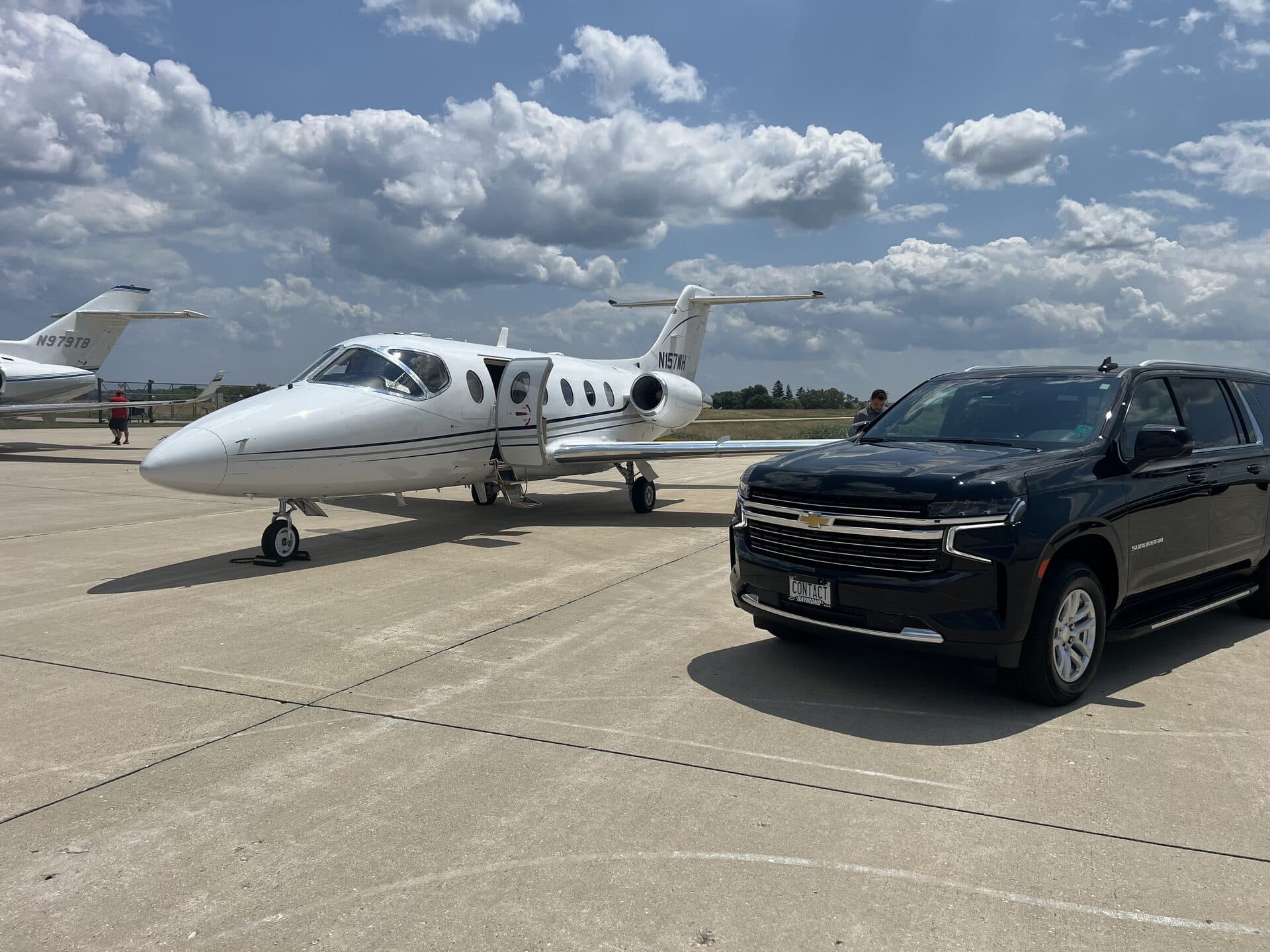Contact Limo Suburban beside private jet on tarmac at executive airport, FBO pickup service near Chicago